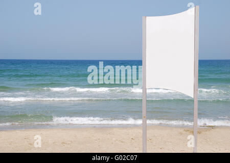 A Blank white Sign on a pole by the Sea side Stock Photo