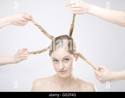 metaphorical image of hands holding different styles of rolls of a blond woman's hair. Stock Photo