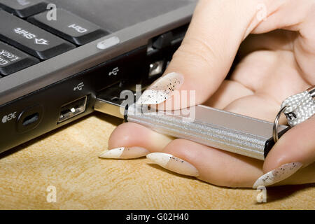 female hands inserting usb flash drive into a laptop computer Stock Photo