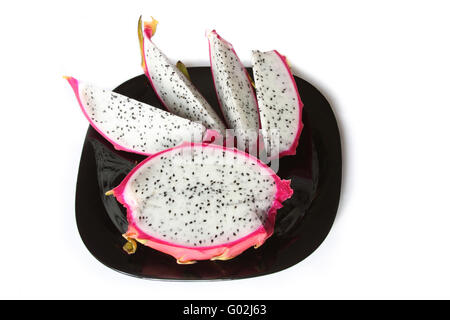 Close-up of dragon fruit slices on black glass plate. Isolated on white Stock Photo