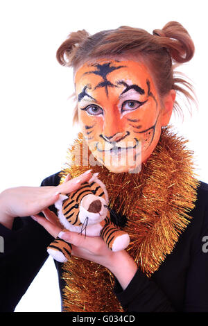 Girl in appearance a tiger with a toy tiger cub. Stock Photo