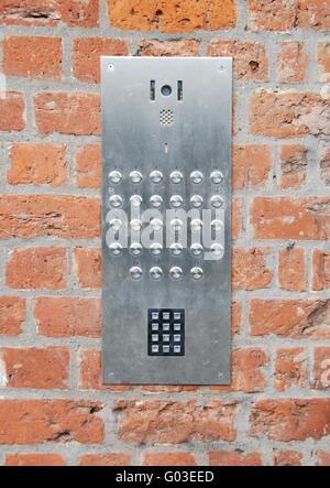 close-up on a intercom doorbell and access code panel on brick wall residential building Stock Photo