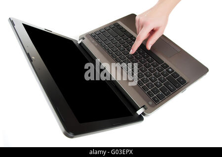 female hand pushing a button on laptop keyboard with the finger with black copy-space to place advert Stock Photo