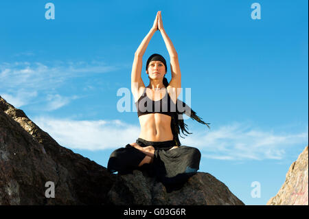 beautiful woman sitting in lotus pose on the beach Stock Photo