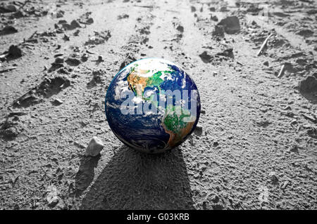 The Earth globe on rocky Mars like surface. Concepts of Earth protection Stock Photo