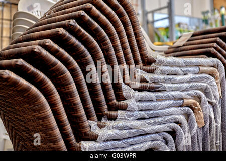 Stack of new wicker patio chairs in a retail store Stock Photo