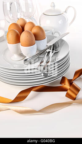 Brown eggs with plates for Easter breakfast on whi Stock Photo
