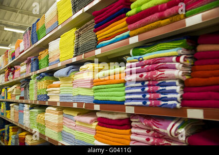 shelves of shop with varicoloured towels and fabri Stock Photo