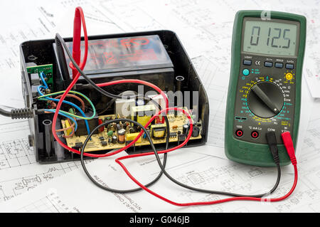 Testing old battery voltage with digital multimeter Stock Photo