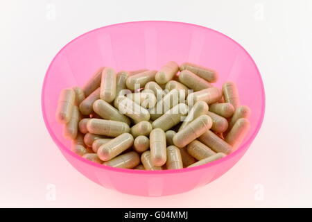 Pink bowl filled with green prescription pills Stock Photo