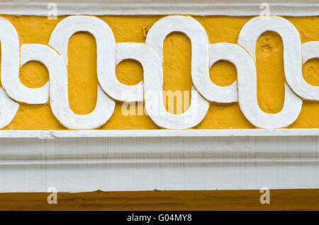 white and yellow concrete ornament on the wall, India Stock Photo