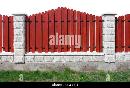 Fragment of a new rural fence. The fence is made of red wooden planks, columns and the base are made from white bricks. Isolated Stock Photo