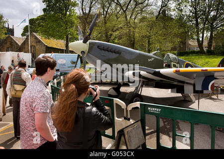 UK, England, Yorkshire, Haworth 40s Weekend, couple photographing replica Spitfire fighter aircraft Stock Photo