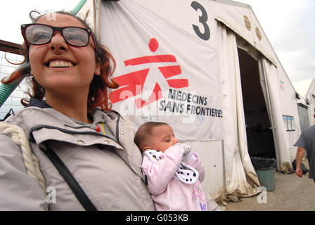 A young Syrian woman with her child close to the larger tents set up by MSF in the field of Idomeni . Idomeni / Greece April 03, Stock Photo