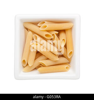 Uncooked penne rigate in a square bowl isolated on white background Stock Photo