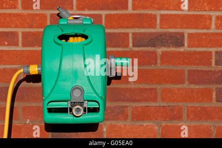 garden hose reel kit installed on a brick wall (copy-space available) Stock Photo