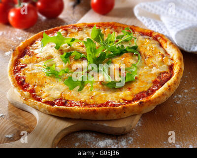 Cooked whole cheese and tomato Margherita pizza with rocket Stock Photo
