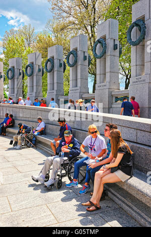 Washington DC, USA - May 2, 2015: Tourists and War Veterans and guardians of Honor Flight nonprofit organization near Pillars on National World War 2 Memorial, National Mall. Stock Photo