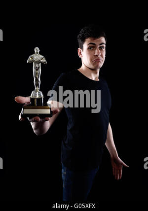 young man holding fake oscar award Stock Photo