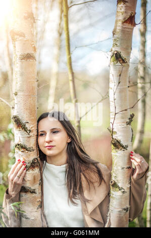 young pretty woman holding birch trees Stock Photo