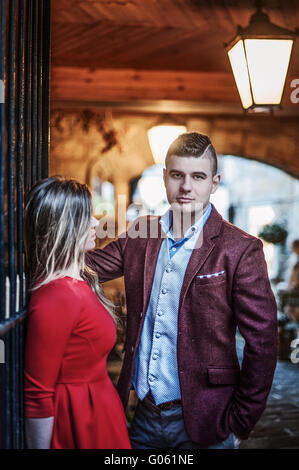 young couple standing at the gate in old town Stock Photo