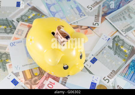 Piggy bank on top of euro bills Stock Photo