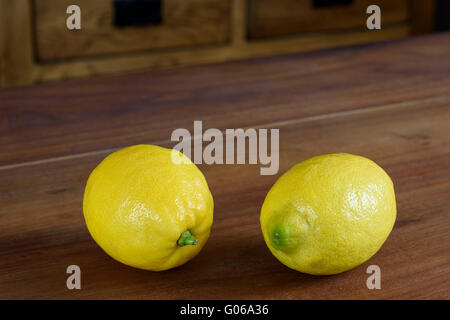 Pair of whole Lemons on a wooden table top Stock Photo