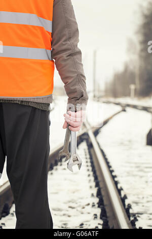 Worker with adjustable wrench in the hands on rai Stock Photo