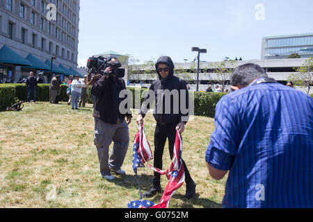 Burlingame, California, USA. 29th April, 2016. An anti-trump protestor rips apart an American flag, and then burns it, after taking it from a Trump supporter outside of the California Republican Convention at the Hyatt Regency in Burlingame, CA. Credit:  John Orvis/Alamy Live News Stock Photo