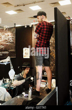 Brighton UK 30th April 2016 - Tattoo artists working at the 9th Annual Brighton Tattoo Convention held in the Brighton Centre this weekend   Simon Dack/Alamy Live News Stock Photo