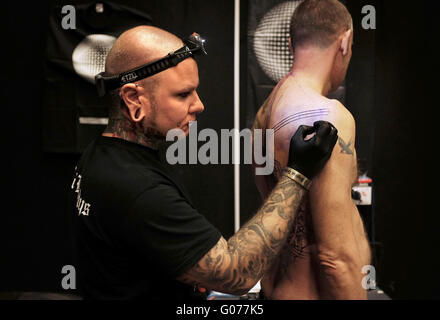 Brighton UK 30th April 2016 - Tattoo artists working at the 9th Annual Brighton Tattoo Convention held in the Brighton Centre this weekend  © Simon Dack/Alamy Live News Credit:  Simon Dack/Alamy Live News Stock Photo