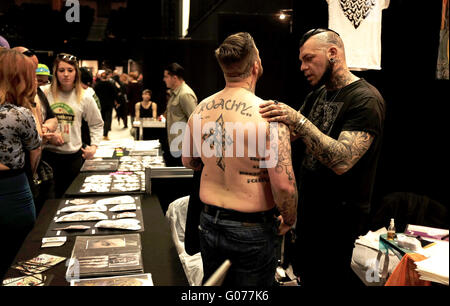 Brighton UK 30th April 2016 - Tattoo artists working at the 9th Annual Brighton Tattoo Convention held in the Brighton Centre this weekend  Credit:  Simon Dack/Alamy Live News Stock Photo