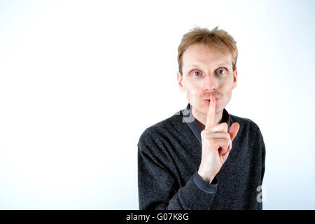 Blonde man who has his finger at the mouth