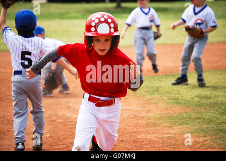 Little league baseball player running bases Stock Photo