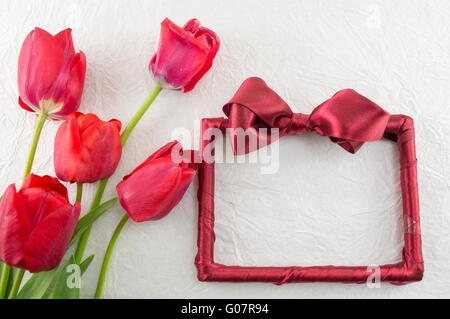 Red tulips and a decorated photo frame a silk fabric Stock Photo