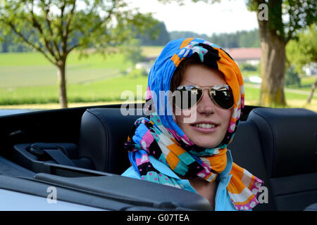 Young woman with sunglasses and headscarf in the c
