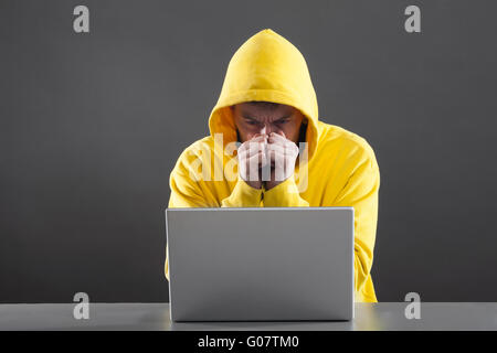 man in a yellow jacket working on the Internet Stock Photo