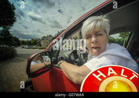 Driver of a car at a traffic control stretches out Stock Photo