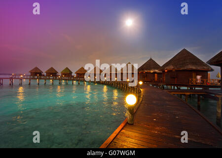 houses on piles on water at night in  fool moon li Stock Photo