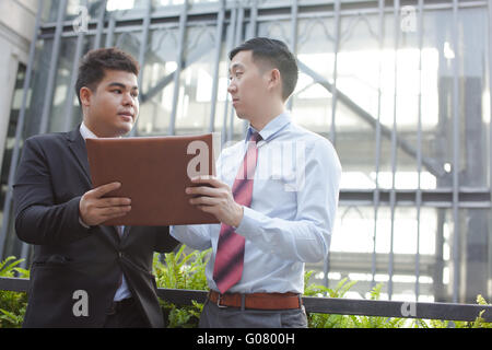 Young professionals discussing business outdoor Stock Photo