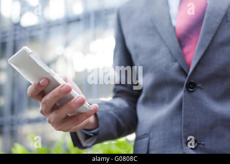Business man using a cellphone (focus on cellphone) Stock Photo