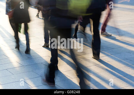 Crowd on the sidewalk at sunset with long shadows Stock Photo