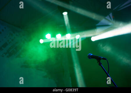 Microphone on stage with green lights and fog Stock Photo