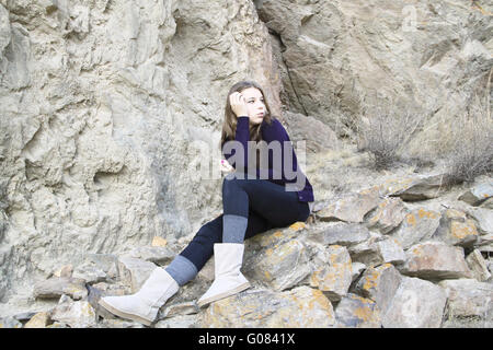 Thoughtful young girl on the background of rocks Stock Photo