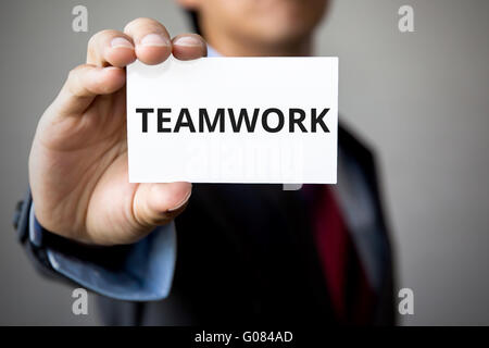 Businessman presenting 'TEAM WORK' word on white card. Stock Photo