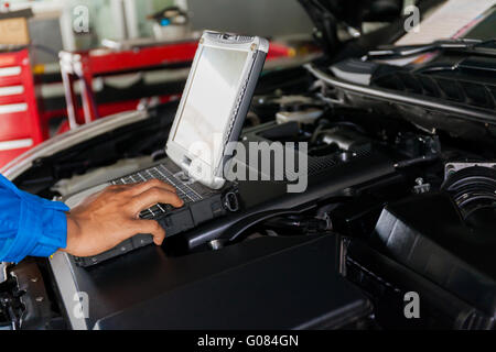 Mechanic using Diagnostic machine tools ready to be used with car Stock Photo