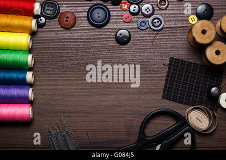 buttons, needles and multicolored threads on the w Stock Photo