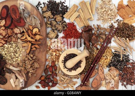 Chinese herb selection used in traditional alternative herbal medicine with mortar and pestle and chopsticks. Stock Photo