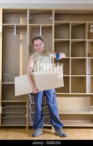 The man is engaged in repair and furniture assembl Stock Photo