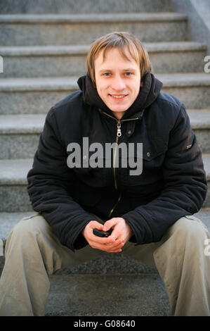 portrait of smile positive young man with phone Stock Photo